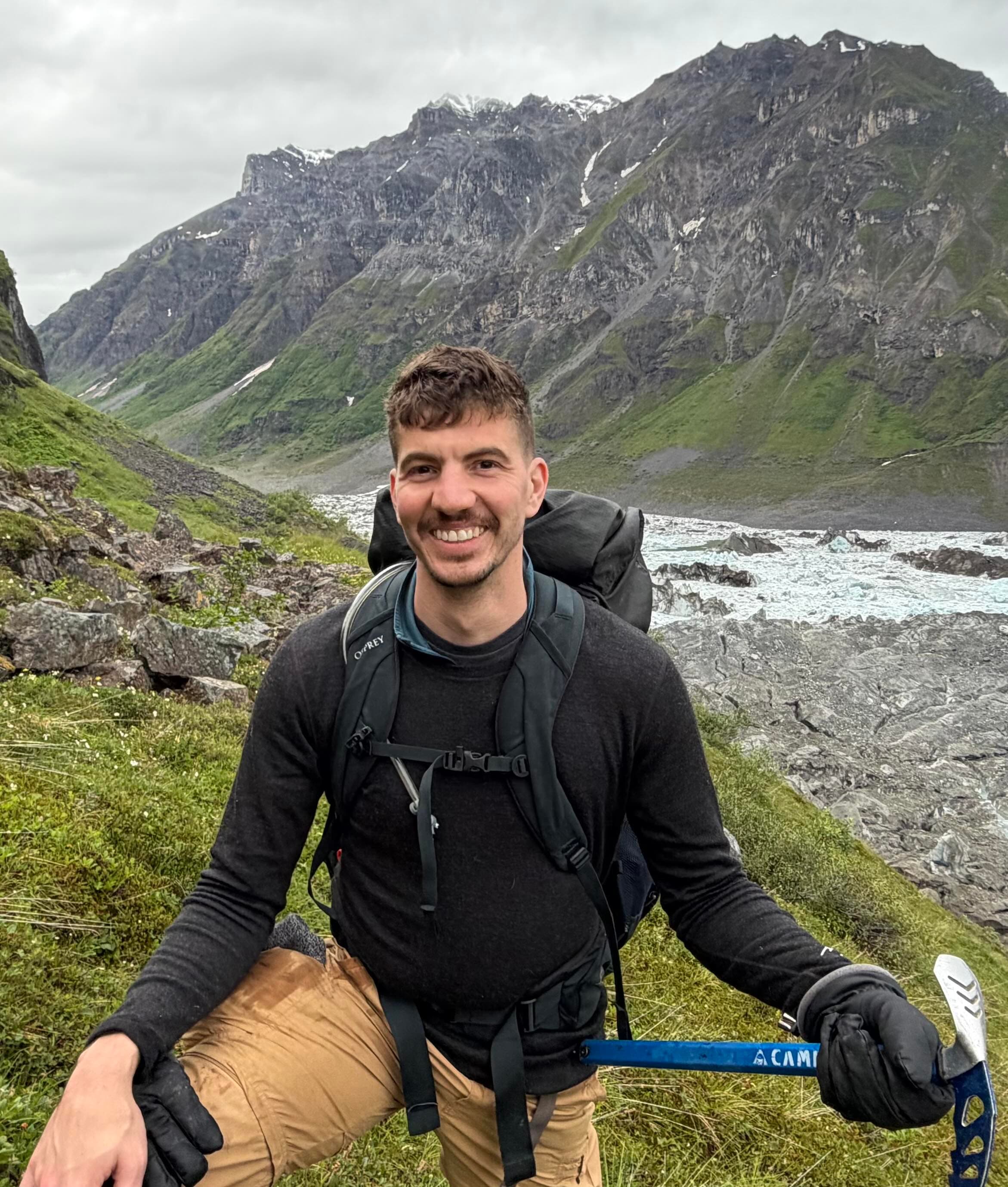 Christopher Heinrich smiling on a mountain trail in Alaska